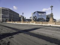 a empty intersection of an urban city street with buildings in the background and shadow on the pavement