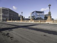 a empty intersection of an urban city street with buildings in the background and shadow on the pavement