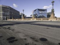 a empty intersection of an urban city street with buildings in the background and shadow on the pavement