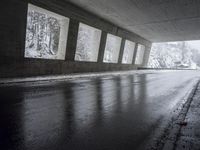 an empty urban road in the rain under a covered bridge of windows and concrete walls