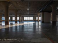 an empty warehouse with many windows and floors and a light fixture in it's ceiling