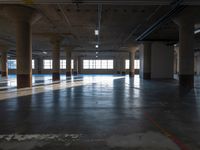 an empty warehouse with many windows and floors and a light fixture in it's ceiling