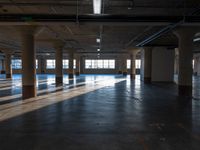 an empty warehouse with many windows and floors and a light fixture in it's ceiling