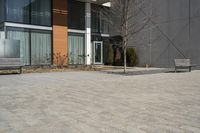 there is an empty walkway with a bench beside it in the background that also has an apartment building