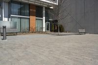 there is an empty walkway with a bench beside it in the background that also has an apartment building