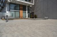 there is an empty walkway with a bench beside it in the background that also has an apartment building