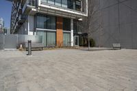 there is an empty walkway with a bench beside it in the background that also has an apartment building