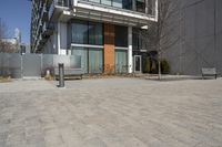 there is an empty walkway with a bench beside it in the background that also has an apartment building