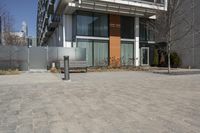 there is an empty walkway with a bench beside it in the background that also has an apartment building