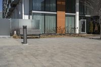 there is an empty walkway with a bench beside it in the background that also has an apartment building