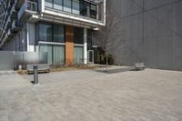 there is an empty walkway with a bench beside it in the background that also has an apartment building