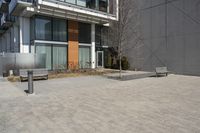 there is an empty walkway with a bench beside it in the background that also has an apartment building