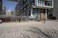 there is an empty walkway with a bench beside it in the background that also has an apartment building