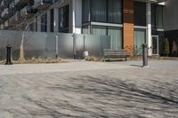 there is an empty walkway with a bench beside it in the background that also has an apartment building