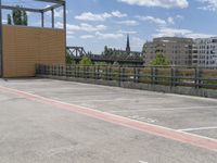 the walkway is empty with parking spaces nearby for people to use on the bike path