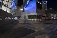 an empty, empty walkway that leads into the buildings and the light is on at night