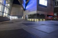 an empty, empty walkway that leads into the buildings and the light is on at night