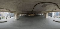 the image shows an empty walkway in the city as seen from below a circular object