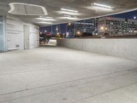 an empty concrete walkway outside with a parking garage below it with a skateboard resting on the ledge of it