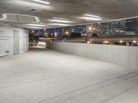 an empty concrete walkway outside with a parking garage below it with a skateboard resting on the ledge of it