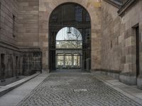 a horse statue and archway at the end of an empty walkway in front of the palace