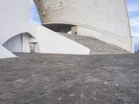 an empty walkway leading to a large white building with steps up to it's top