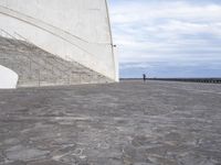 an empty walkway leading to a large white building with steps up to it's top