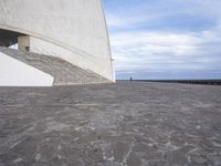 an empty walkway leading to a large white building with steps up to it's top