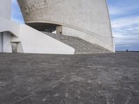 an empty walkway leading to a large white building with steps up to it's top