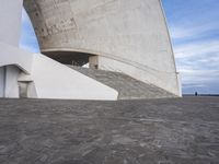 an empty walkway leading to a large white building with steps up to it's top