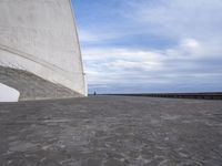 an empty walkway leading to a large white building with steps up to it's top