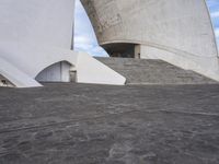 an empty walkway leading to a large white building with steps up to it's top