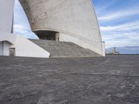 an empty walkway leading to a large white building with steps up to it's top