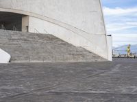 an empty walkway leading to a large white building with steps up to it's top