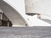 an empty walkway leading to a large white building with steps up to it's top