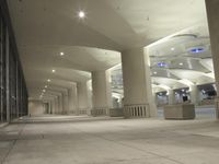 an empty walkway in a very modern building with the lights on and outside windows open