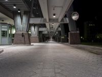 the empty walkway and sidewalk outside of an office building in the dark light, with a circular clock on each end