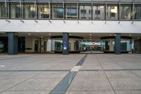 an empty walkway in a large building with an awning and pillars in the middle of it