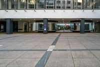 an empty walkway in a large building with an awning and pillars in the middle of it