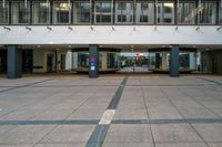 an empty walkway in a large building with an awning and pillars in the middle of it