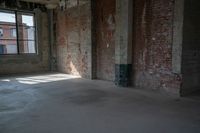 a skateboard stands in the middle of an empty warehouse area with bright sunlight shining through a window