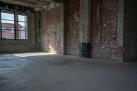 a skateboard stands in the middle of an empty warehouse area with bright sunlight shining through a window