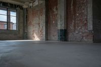 a skateboard stands in the middle of an empty warehouse area with bright sunlight shining through a window