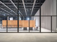 an empty warehouse with glass doors and chairs on the side of it with no people sitting inside