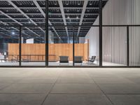 an empty warehouse with glass doors and chairs on the side of it with no people sitting inside