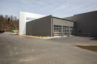 this is an empty warehouse with some large windows in it, along with another building behind the storefront