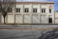 an empty warehouse building in an older industrial city setting - looking into a street, in front of a red brick building