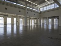 an empty empty warehouse with no roof, lots of windows and light coming in from high ceilings