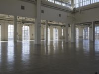 an empty empty warehouse with no roof, lots of windows and light coming in from high ceilings