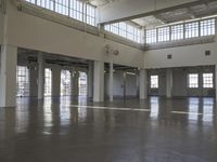 an empty empty warehouse with no roof, lots of windows and light coming in from high ceilings